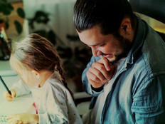 Child on father's lap at computer